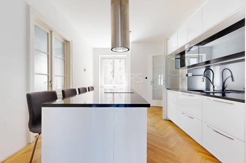 Küche in einer 3-Zimmer-Wohnung mit Bartresen und eingebauten Geräten.