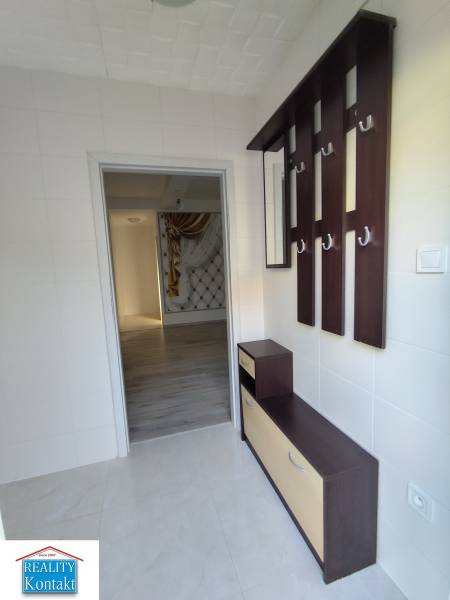 Eingangsflur zu einer Einzimmerwohnung mit Garderobenwand und Ablageschrank.