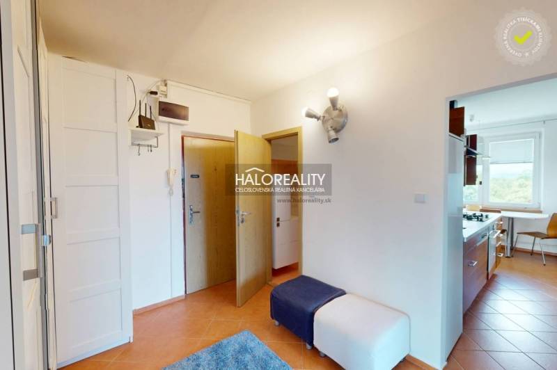 Eingangsflur einer 4-Zimmer-Wohnung mit Verkleidung und einem Raum, der in die Küche führt.