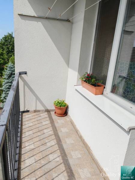 Balkon mit Blumenkästen, der zu einer 3-Zimmer-Wohnung gehört, mit Blick ins Grüne.