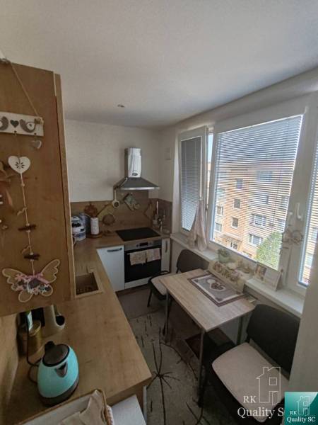 Küche in einer 3-Zimmer-Wohnung mit Holzküche, Esstisch und Geräten.