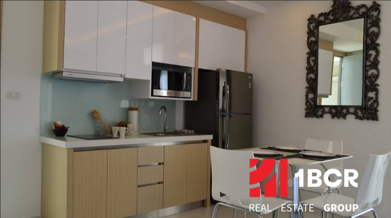 Küche in einer 2-Zimmer-Wohnung mit eingebauten Geräten und Esstisch.