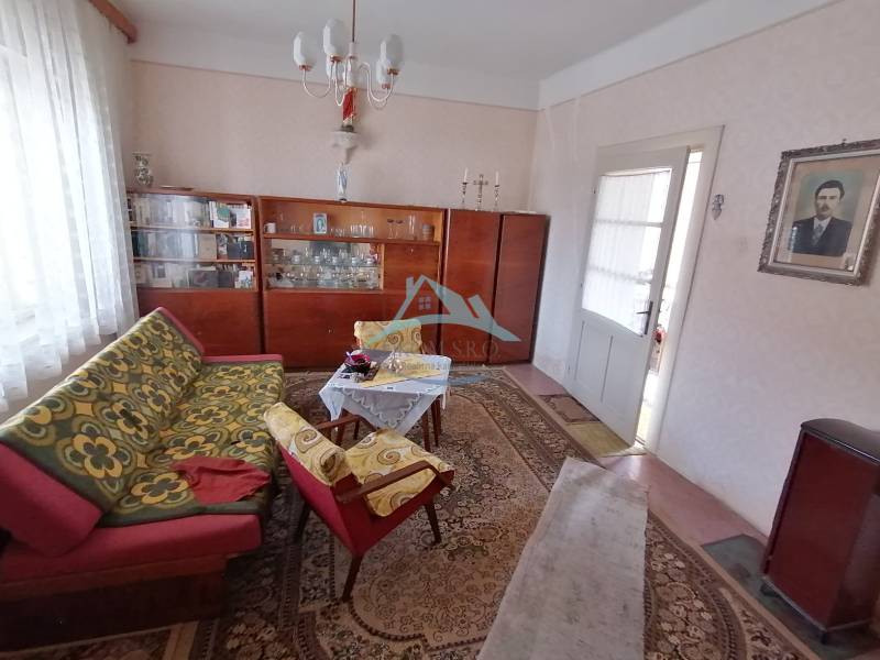 Wohnzimmer in einem Einfamilienhaus mit Retro-Möbeln und gemusterten Teppichen.