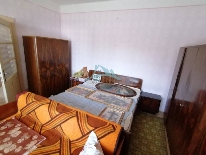 Ein Schlafzimmer in einem Einfamilienhaus mit Bett, Schränken und Bildern an der Wand.