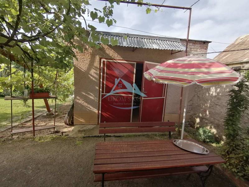 Garten beim Einfamilienhaus in Hrkovce mit Tisch und Sonnenschirm.