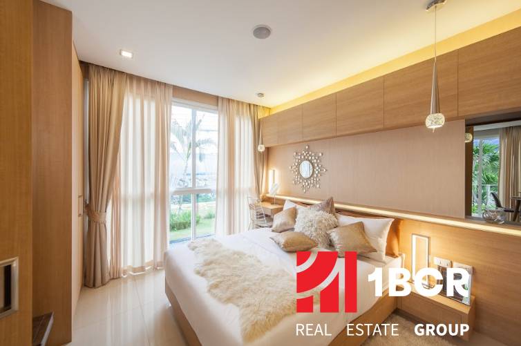 Schlafzimmer in einer 2-Zimmer-Wohnung mit moderner Ausstattung und großen Fenstern, die Tageslicht hereinlassen.