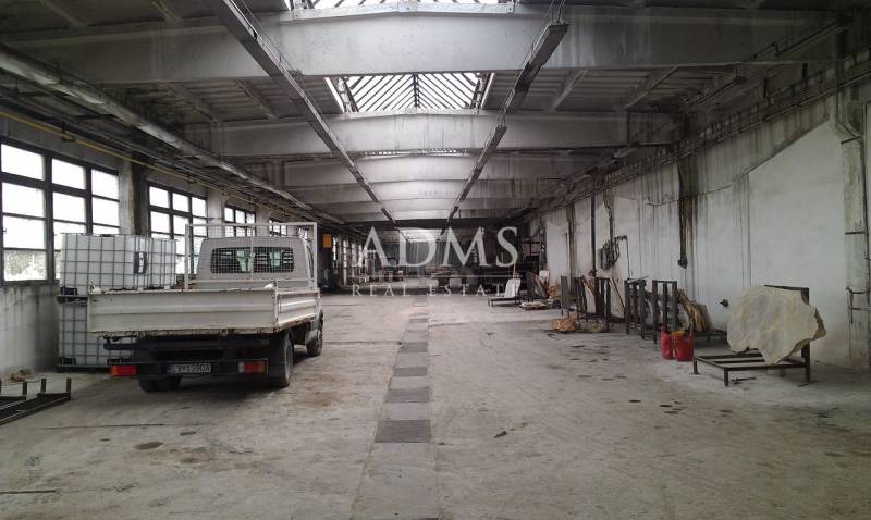 Geräumige Halle mit geparktem Auto und Lagertanks in Levice.