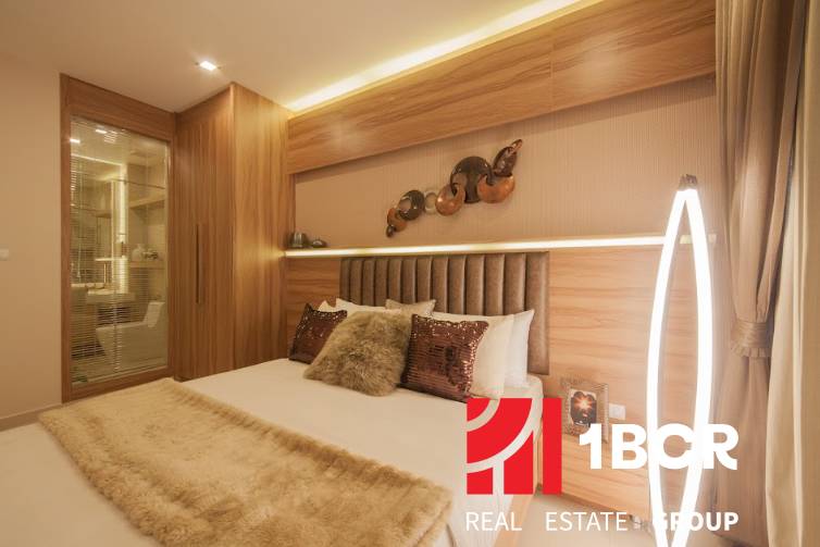 Schlafzimmer in einer 3-Zimmer-Wohnung mit Spiegel, Holzelementen und sanfter Beleuchtung.