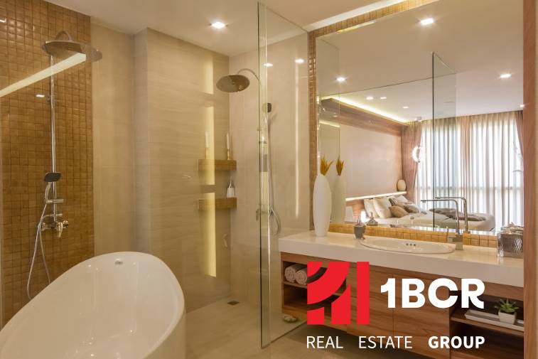Badezimmer in einer 3-Zimmer-Wohnung mit Badewanne, Dusche und großem Spiegel. Elegante Beleuchtung ergänzt den Raum.