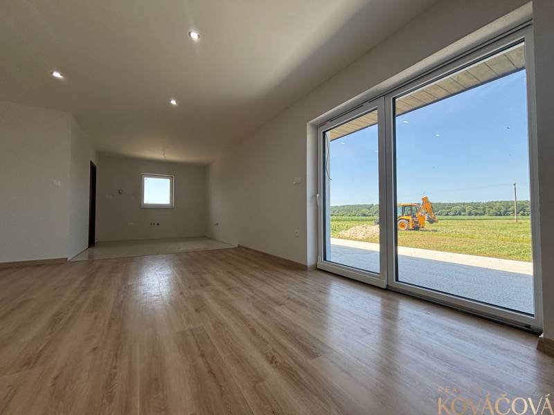 Geräumiges Zimmer mit Laminatboden und großen Glastüren in einem Einfamilienhaus.