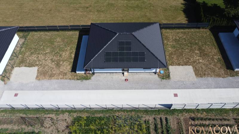 Ein Einfamilienhaus in Podlužany mit Solarpaneelen und einem geräumigen Garten.