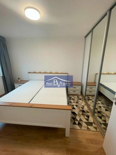 Schlafzimmer in einer 2-Zimmer-Wohnung mit einem Doppelbett und einem Einbauschrank an der Wand.