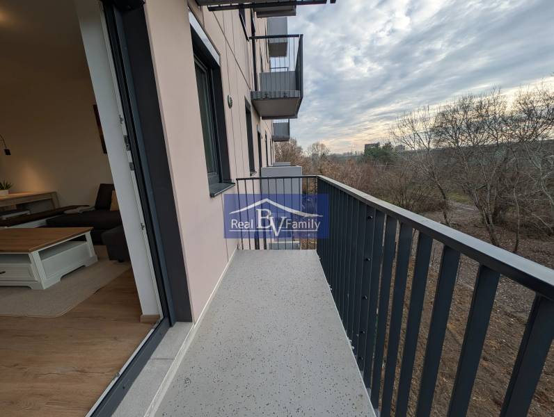 Der Balkon einer 2-Zimmer-Wohnung in der Hraničná-Straße in Bratislava - Ružinov, mit Blick auf die Bäume.