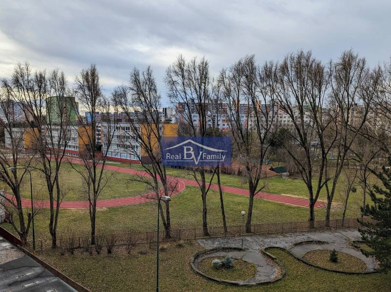 Blick auf das Schulgelände mit Laufbahn und umliegenden Wohnhäusern in Petržalka.
