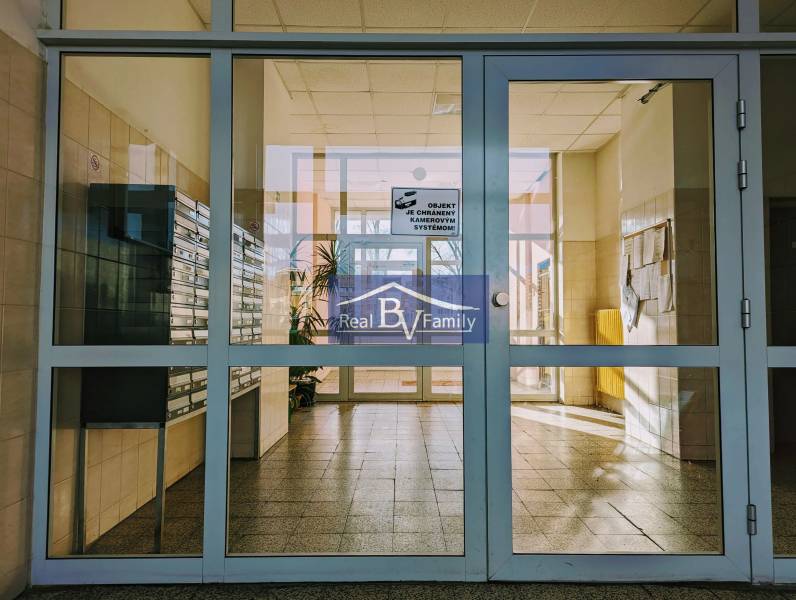 Eingangshalle in einem Wohnhaus mit Briefkästen und Glastüren.