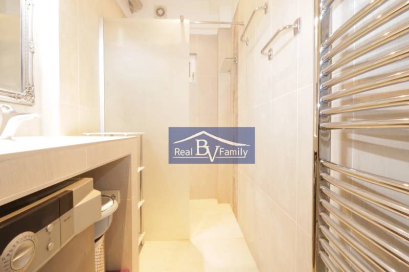 Badezimmer in einer 2-Zimmer-Wohnung mit Waschmaschine, Duschkabine und Handtuchheizkörper.