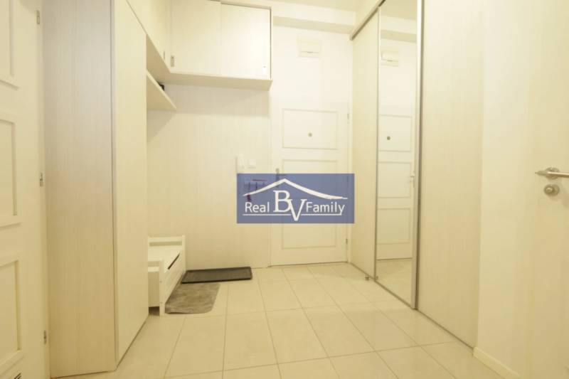 Eingangsflur mit Fliesenboden, Spiegelschrank und Einbauschränken in einer 2-Zimmer-Wohnung.