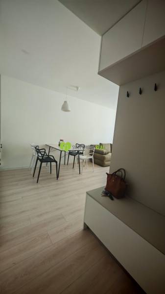 Einzimmerwohnung mit hellem Möbel und Holzboden, enthält einen Esstisch.