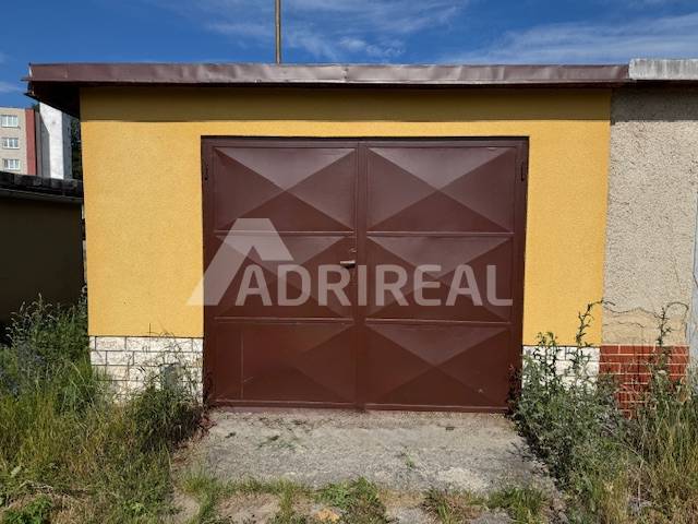 Braune Garage in der Záhradná-Straße in Svit mit Pflanzen rundherum.