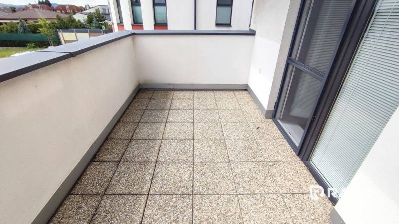 Der Balkon einer 2-Zimmer-Wohnung in der Hroznová-Straße in Trenčín mit Fliesen und Geländer.