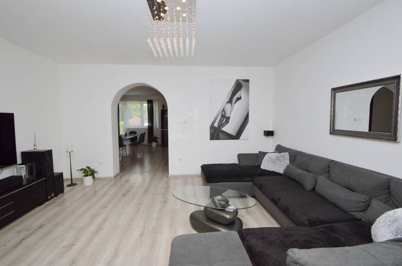 Wohnzimmer in einem Einfamilienhaus mit großer Couch und moderner Einrichtung.