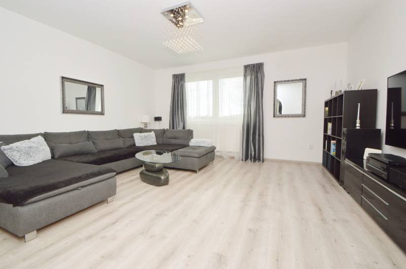Wohnzimmer mit Sofa, Tisch und Schrank im Einfamilienhaus.