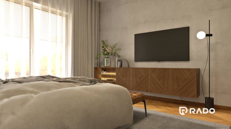 Schlafzimmer in einer 2-Zimmer-Wohnung mit Fernseher, Kommode und dekorativen Pflanzen.