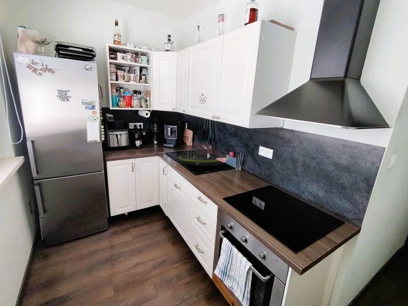 Küche in einer 2-Zimmer-Wohnung, ausgestattet mit Geräten und Stauraum.