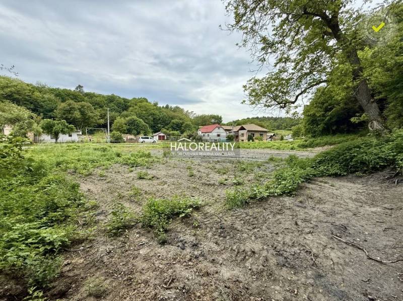 Baugrundstück in Selce mit angrenzendem Grün und Blick auf die Häuser im Hintergrund.