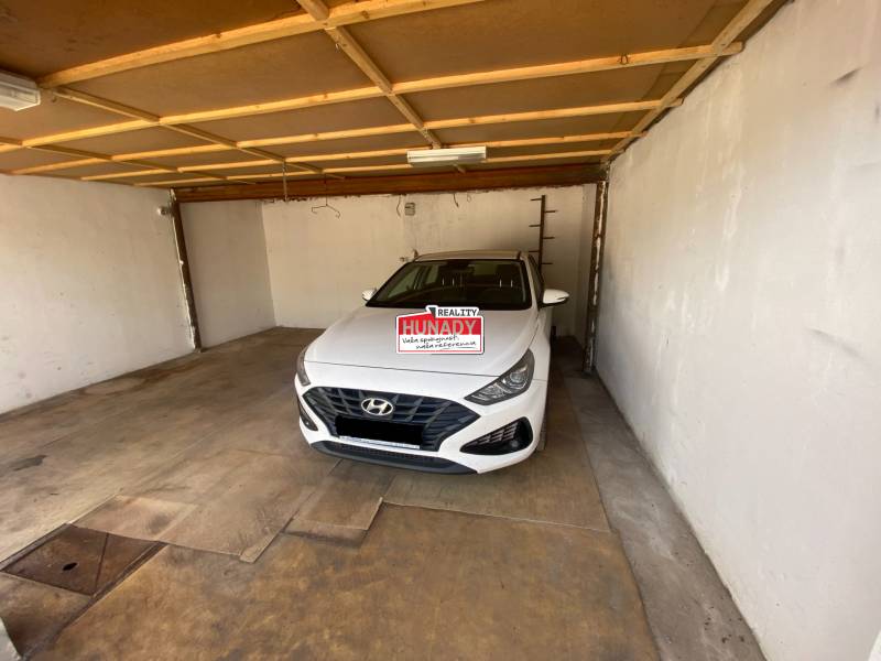 Der Innenraum der Garage mit einem weißen Hyundai-Auto, das drinnen geparkt ist.