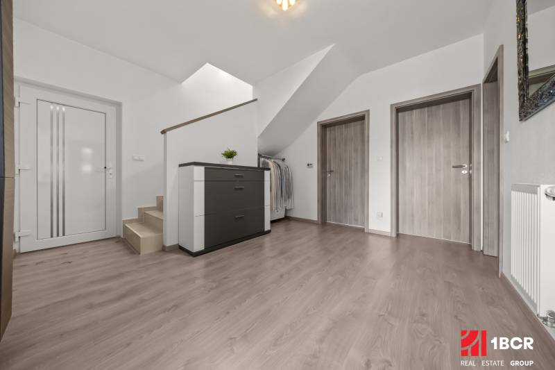Flur mit Treppe und drei Türen in einer 4-Zimmer-Wohnung mit Kommode und Garderobe.
