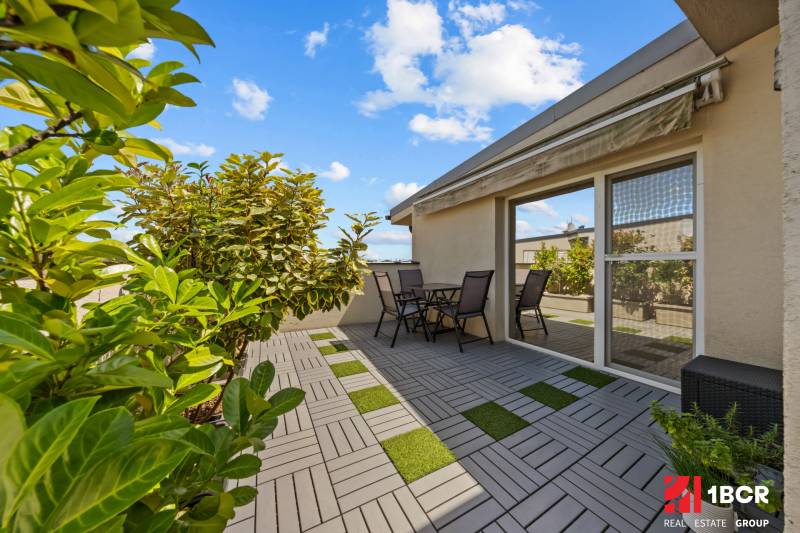 Terrasse bei einer 4-Zimmer-Wohnung in der Záhradná-Straße in Most pri Bratislave, Sitzgelegenheiten und Pflanzen.