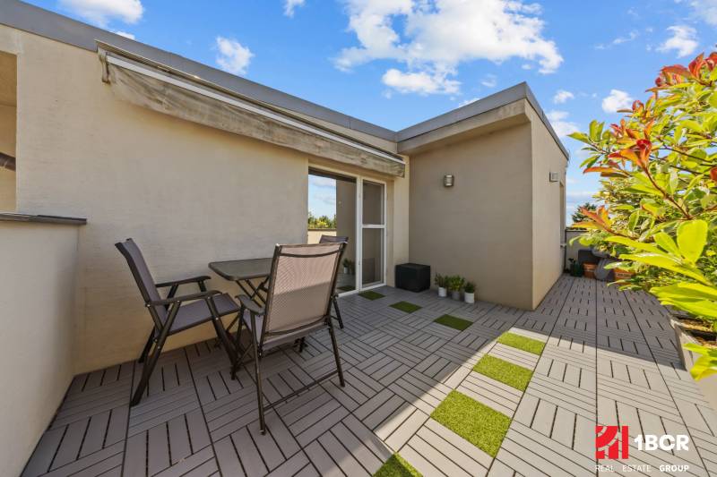 Terrasse mit Sitzbereich in einer 4-Zimmer-Wohnung mit Grünfläche und Markise in der Záhradná-Straße.