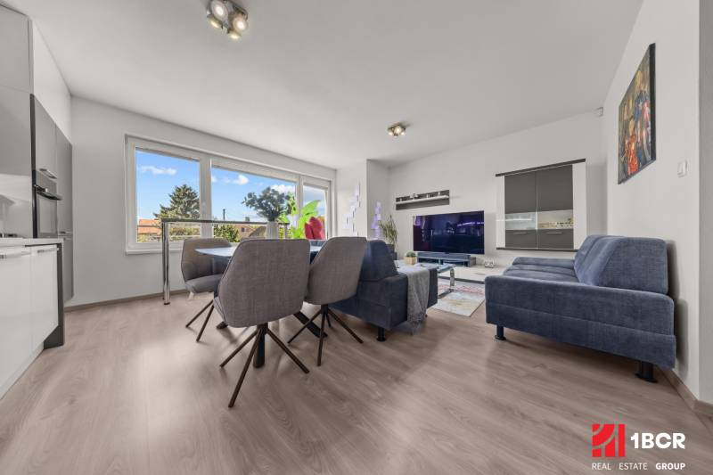 Wohnzimmer in einer 4-Zimmer-Wohnung mit Esstisch, Sofa und Fernseher.