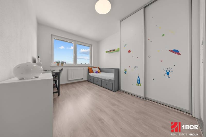 Kinderzimmer in einer 4-Zimmer-Wohnung mit Bett, Schreibtisch und Schrank mit Weltraummotiven.