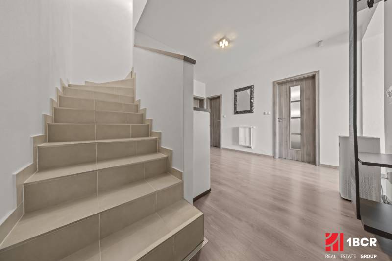 Eine Treppe in einer 4-Zimmer-Wohnung mit Holzboden und weißen Wänden.