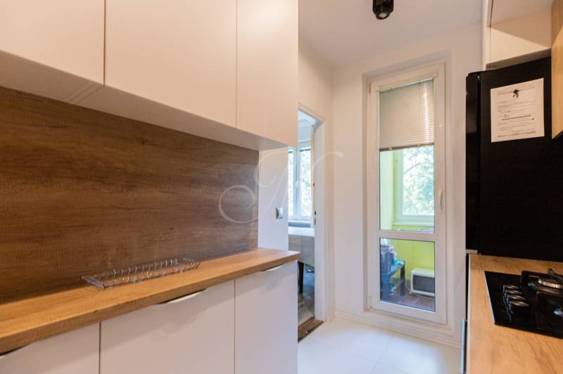 Küche in einer 4-Zimmer-Wohnung mit Holzarbeitsplatte und Zugang zum Balkon.