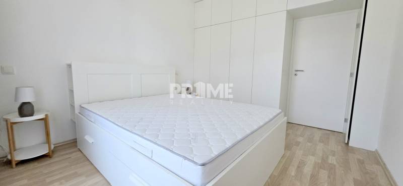 Schlafzimmer in einer 2-Zimmer-Wohnung mit weißen Möbeln und Einbauschrank.