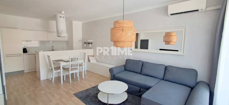 Gemütliches Wohnzimmer mit Küche in einer 2-Zimmer-Wohnung mit elegantem Möbeln und Beleuchtung.