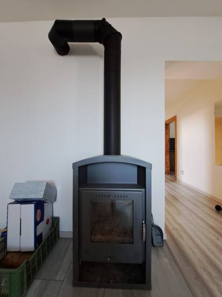 Kaminofen im Einfamilienhaus, minimalistisches Design in hellem Interieur.