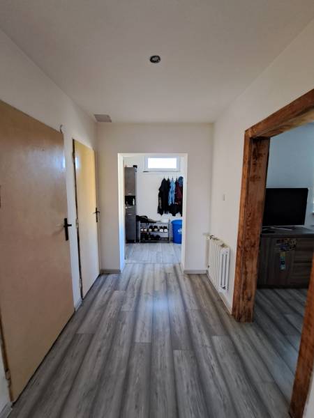 Flur im Einfamilienhaus mit Laminatboden, Holzrahmen und Schuhlager.