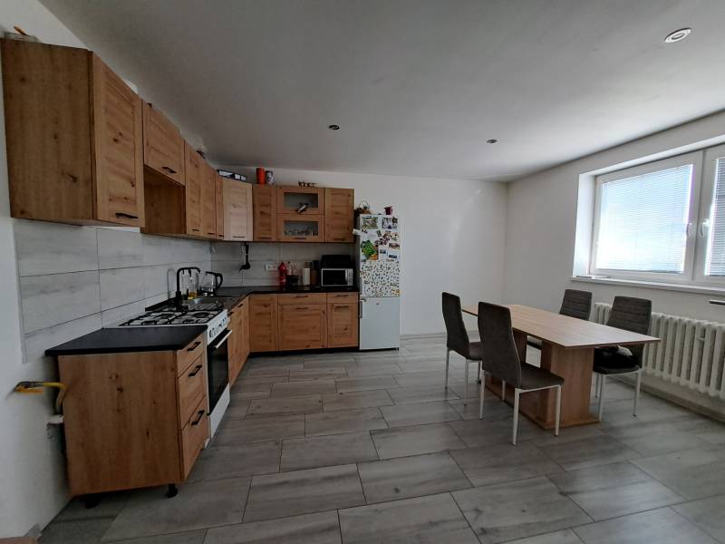 Küche in einem Einfamilienhaus mit Holzschränken, Esstisch und Geräten.