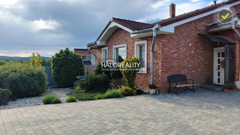 Ein Einfamilienhaus in Kalinovo mit einer Ziegelfassade und einem gepflegten Garten.