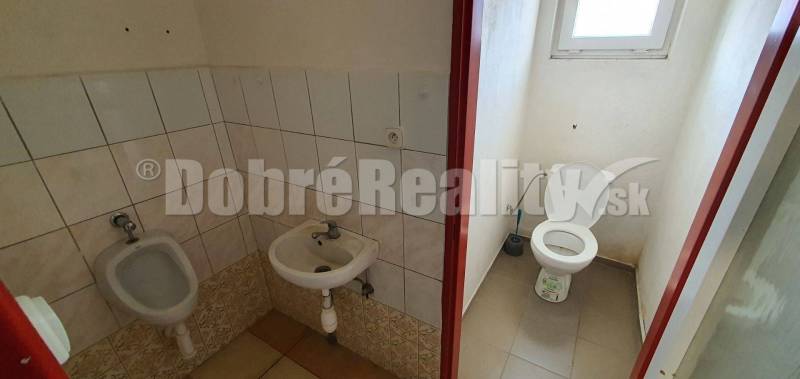 Toilette mit Waschbecken und Urinal in Geschäftsräumen.