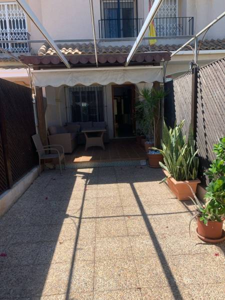 Die Terrasse des Einfamilienhauses in Santiago de la Ribera mit Sitzgelegenheiten und Grünflächen.