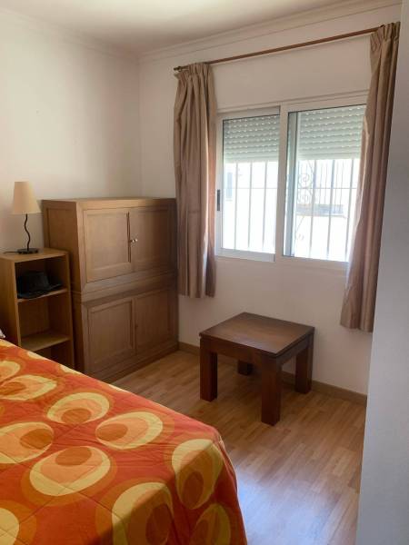 Ein Zimmer in einem Einfamilienhaus mit Holzmöbeln und einer Bettdecke.