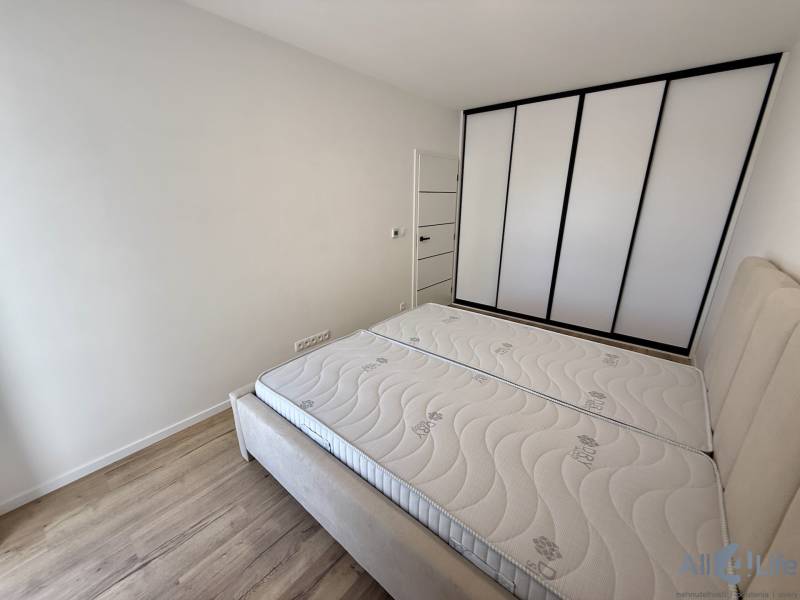Schlafzimmer in einer 2-Zimmer-Wohnung mit Einbauschrank und Holzboden.