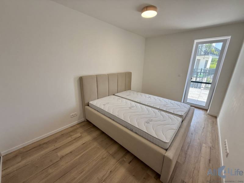 Schlafzimmer mit Doppelbett, Matratzen und Holzboden in einer Zweizimmerwohnung.