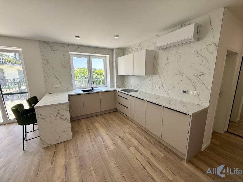 Helle Küche mit Marmorfliesen und Holzboden in einer Zweizimmerwohnung.