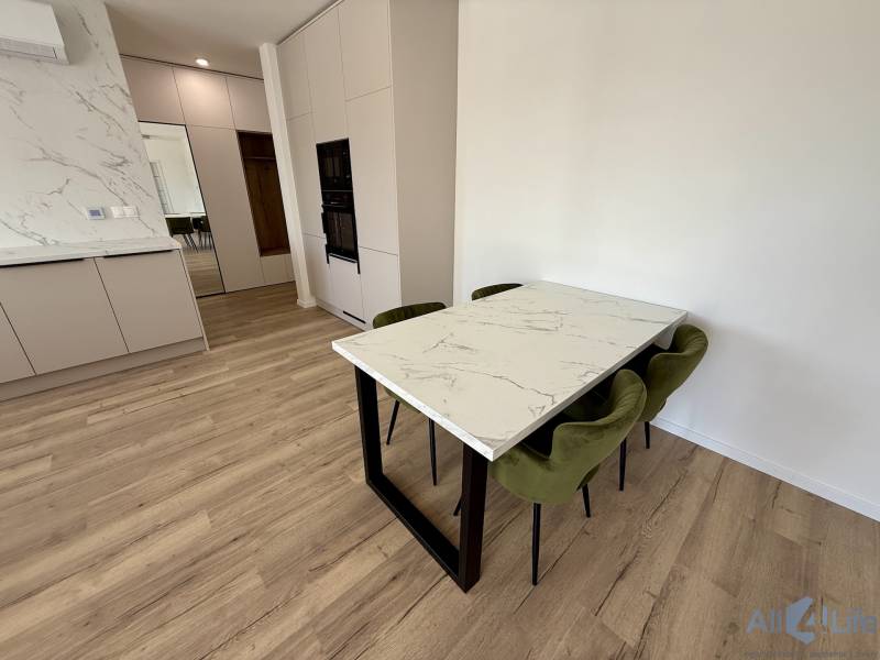 Küchenbereich mit Tisch und Stühlen in einer 2-Zimmer-Wohnung.